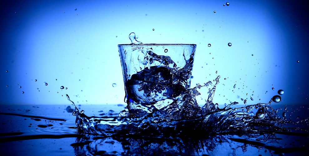 verre d'eau sur fond d'eau éclaboussée